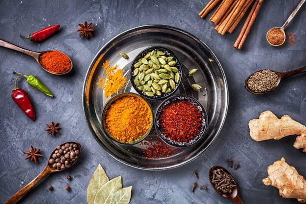 Various Spices like turmeric, cardamom, chili, bayberry, bay leaf, paprika, ginger, cinnamon, cumin, star anise and clove on grunge background